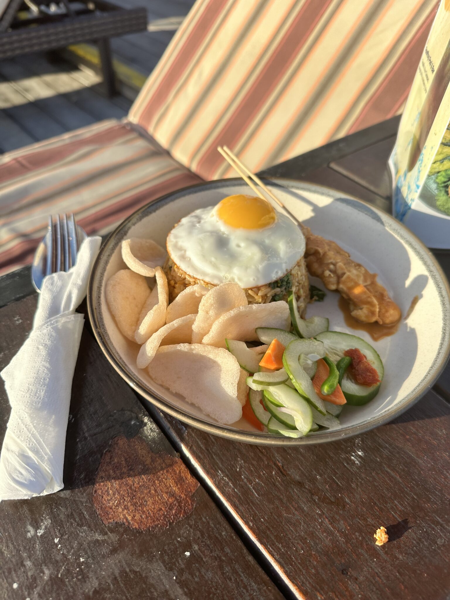 A delicious plate of Nasi Goreng served with shrimp chips and sambal sauce
