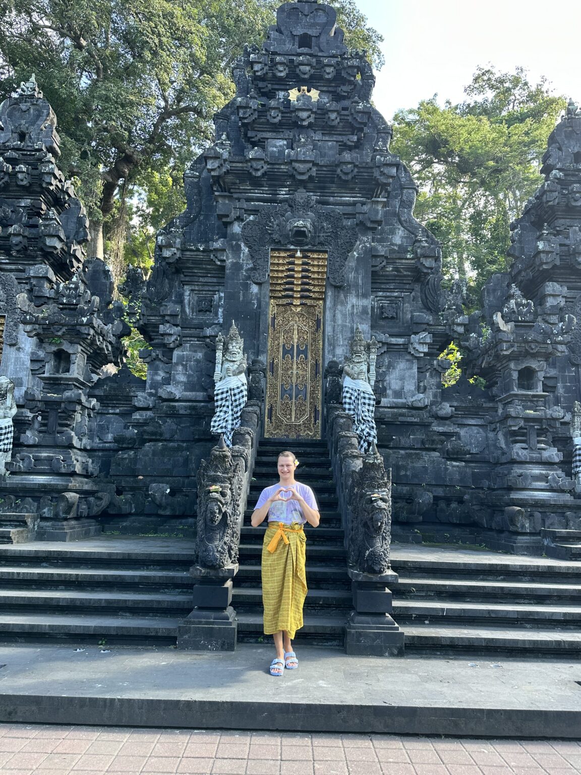 A traveler in a sarong, standing before an ancient temple gate